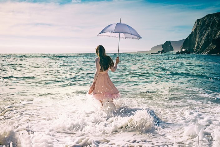 Girl with umbrella in the sea